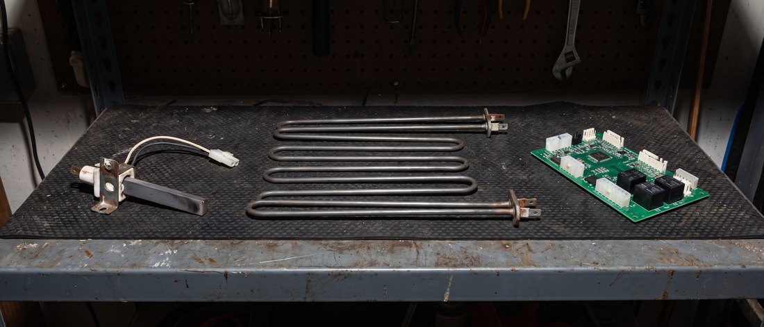 Oven igniter, bake element, and control board on a workbench mat